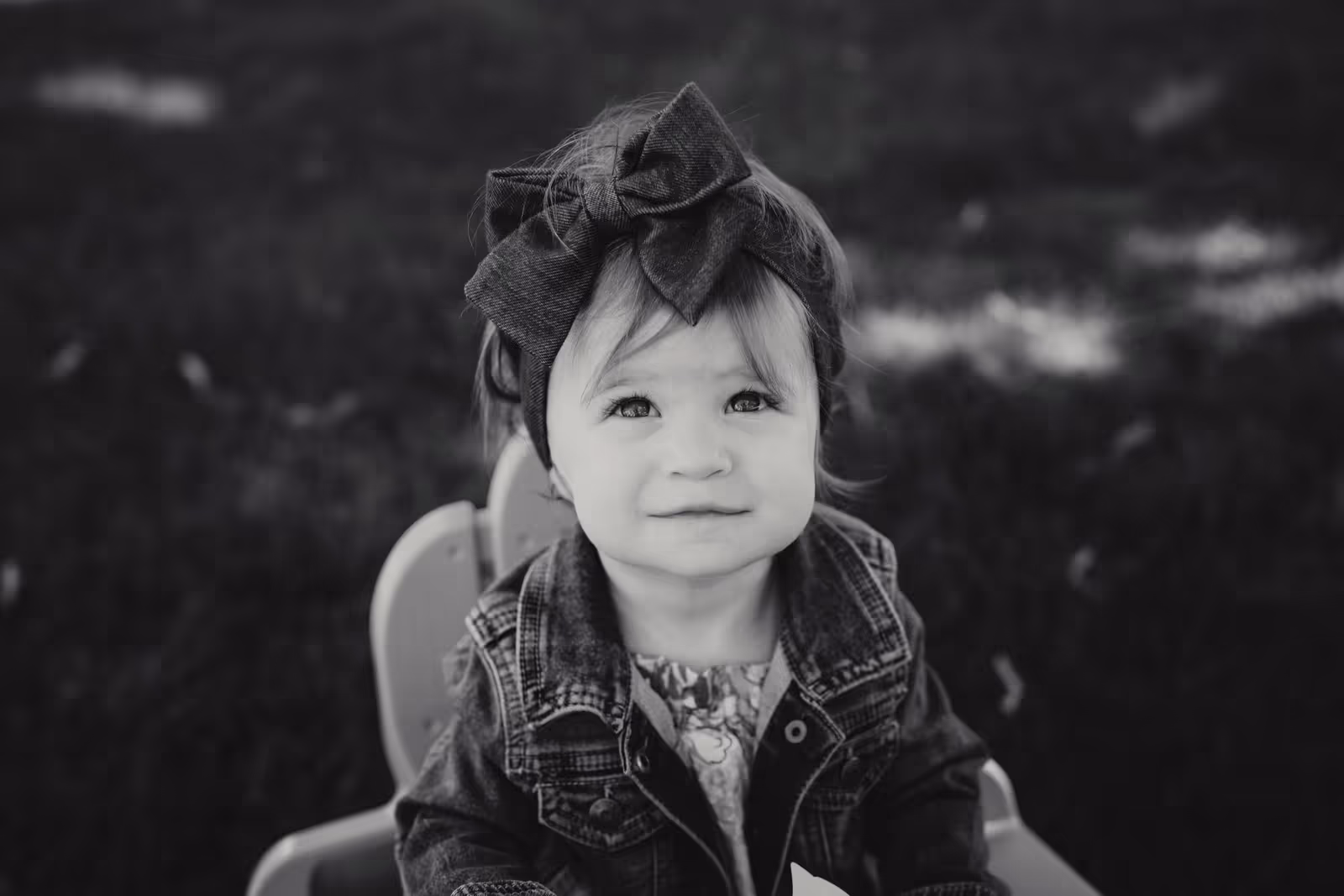 Black-and-white portrait of a young child wearing a bow